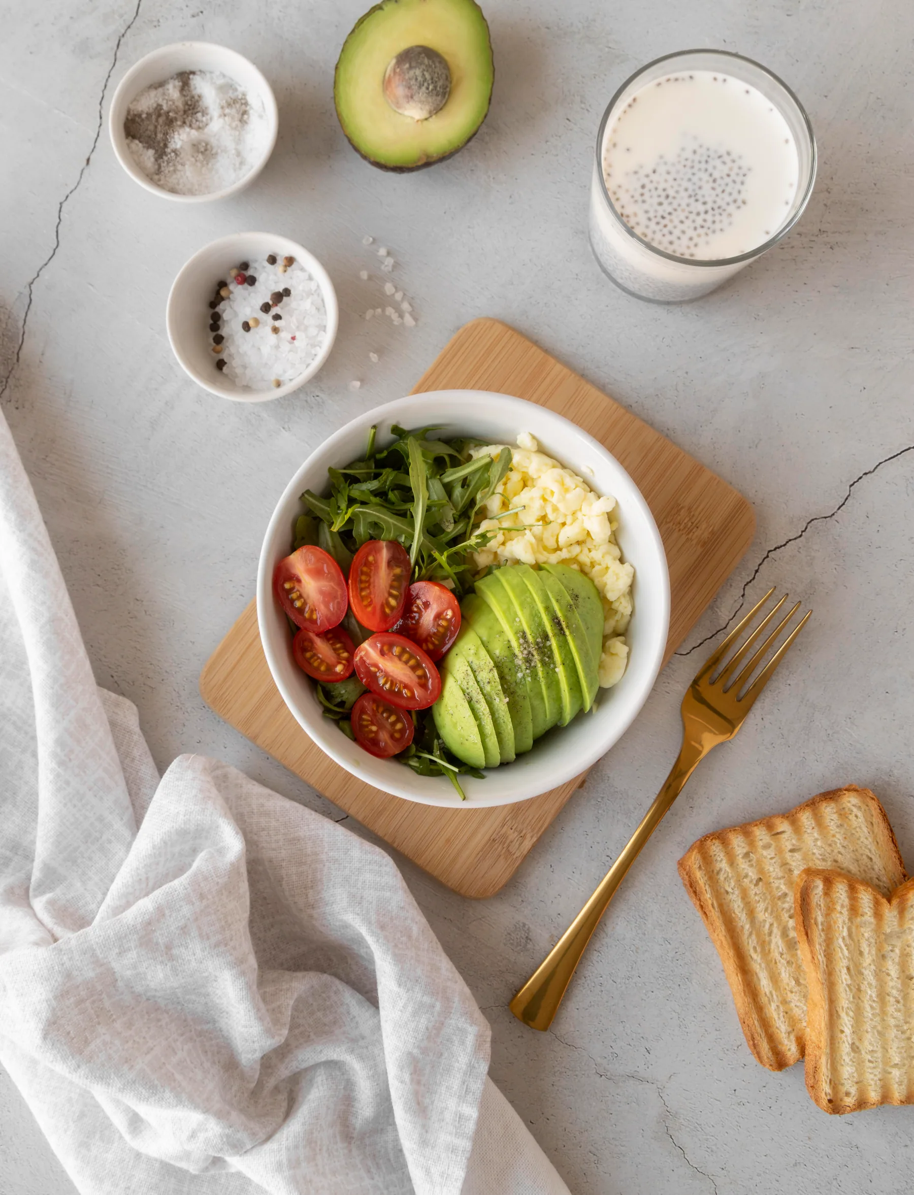 Bol con aguacate, tomate y hojas verdes